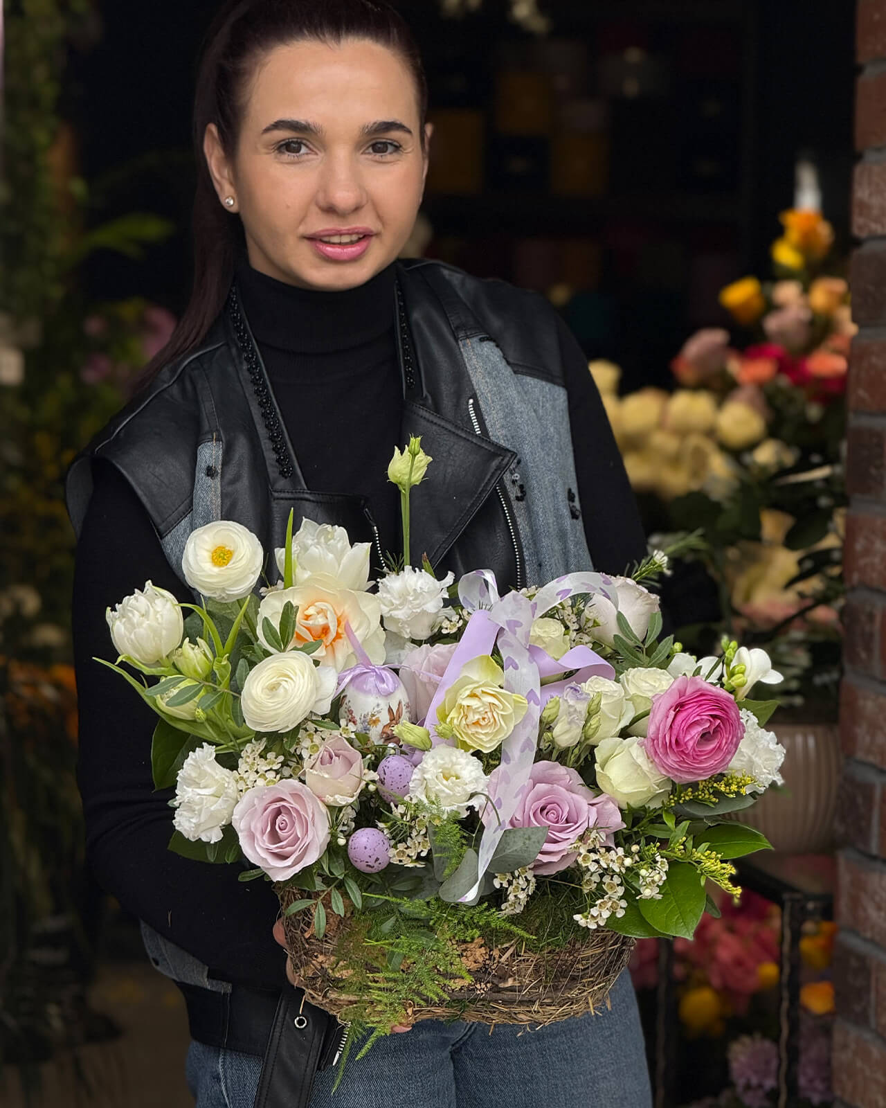 Aranjament floral in cos cu trandafiri mov, lalele albe, ranunculus, lisianthus si frezii albe „Meadow Glow”