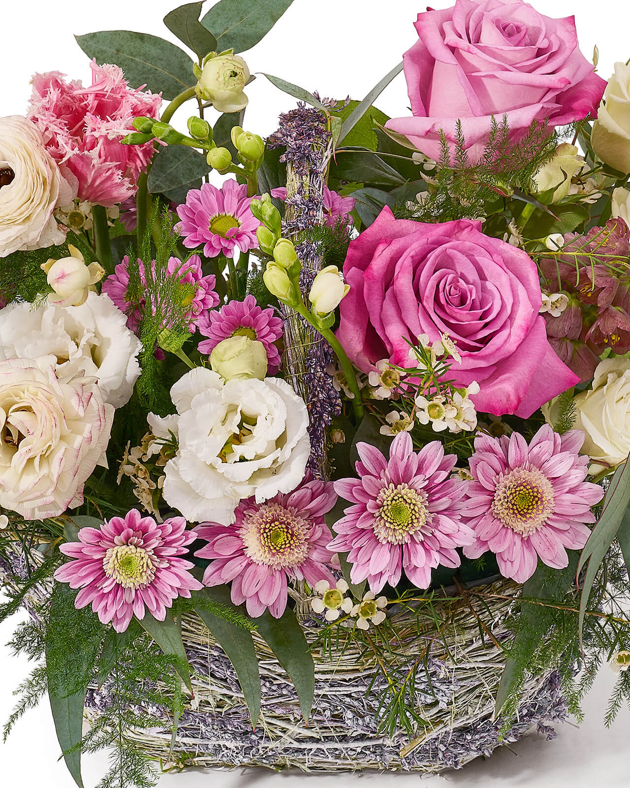 Aranjament floral in cos cu trandafiri mov, ranunculus alb, lalele roz, minirose si frezii albe „Blushing Petals”