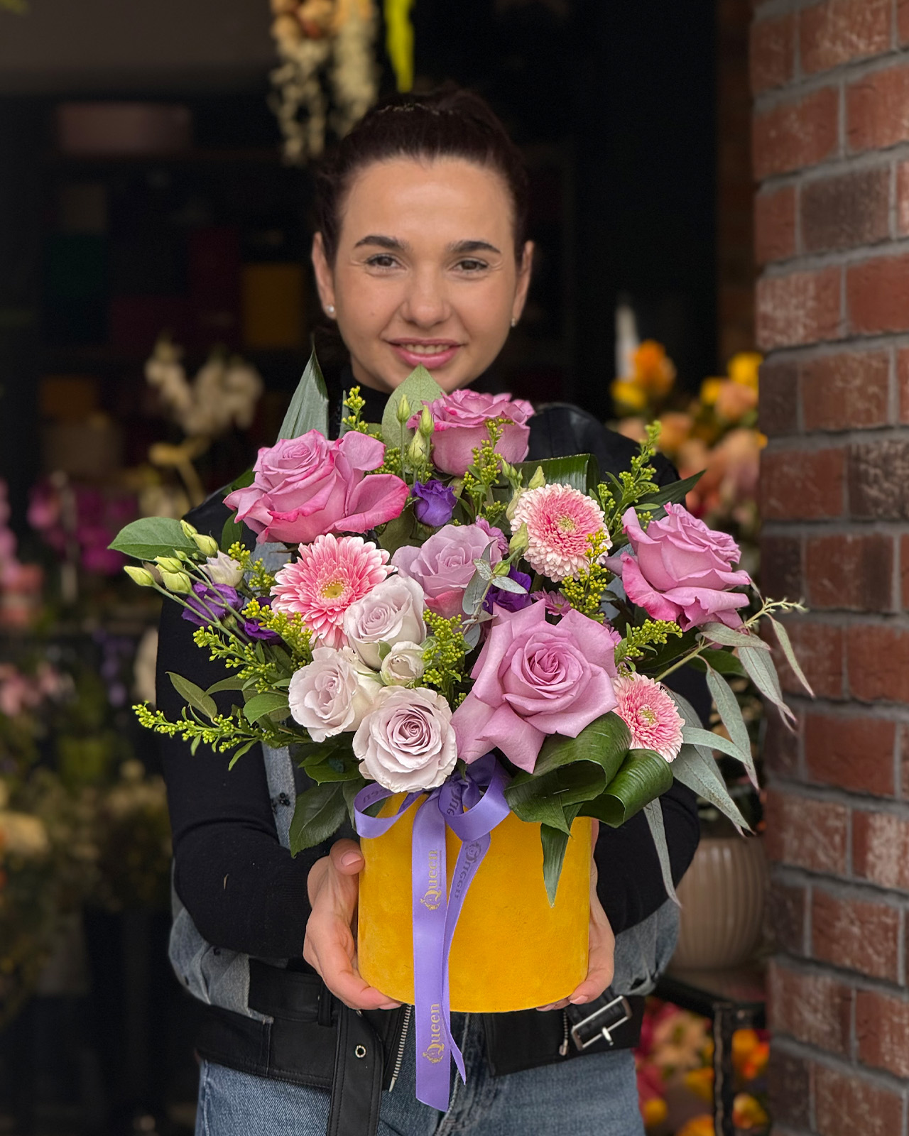Aranjament floral in cutie de catifea galbena cu trandafiri mov, minigerbera roz, lisianthus si santini „Harmony of Roses”