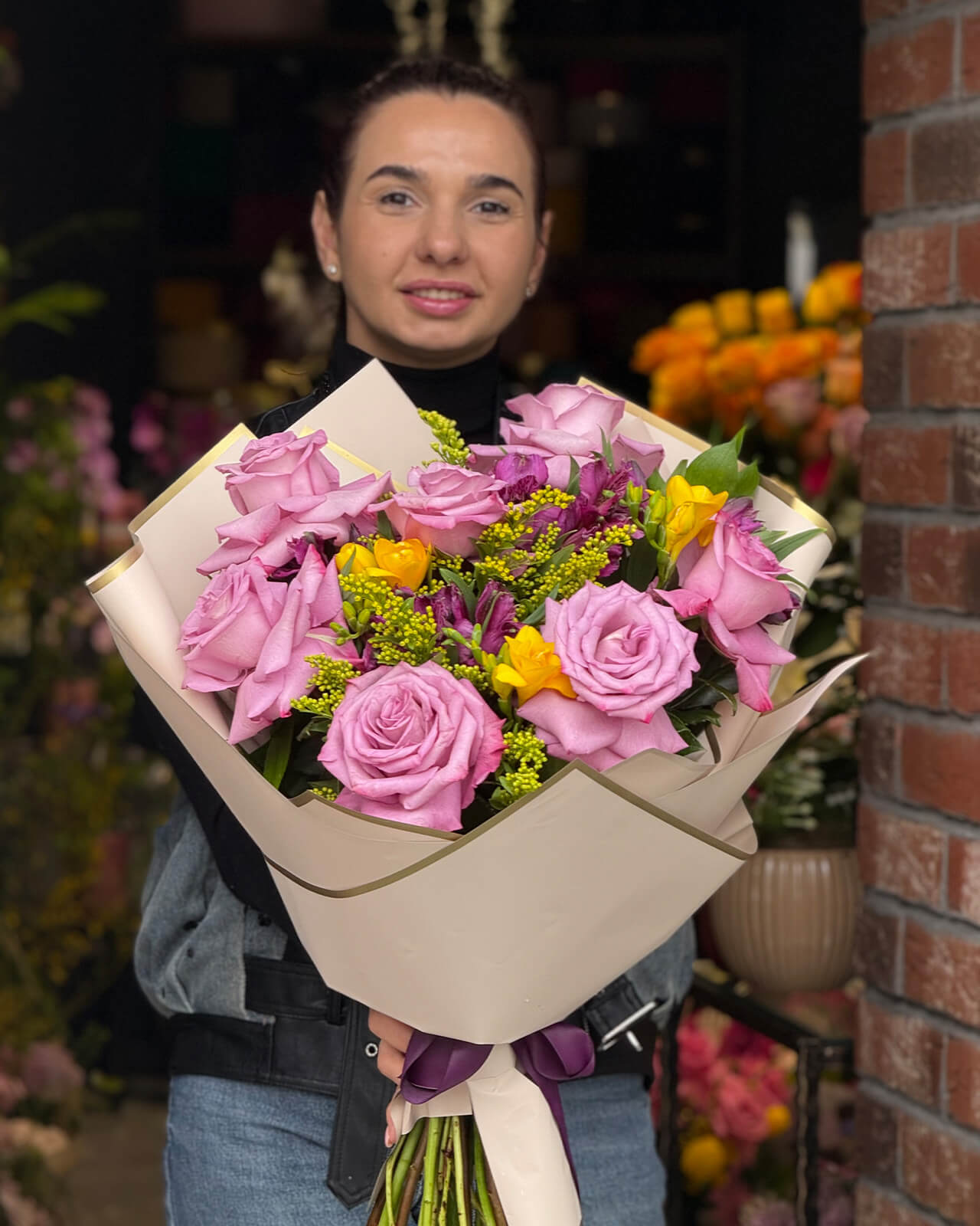 Buchet cu trandafiri mov, alstroemeria mov, frezii galbene, solidago si ruscus „Lavender Gleam”